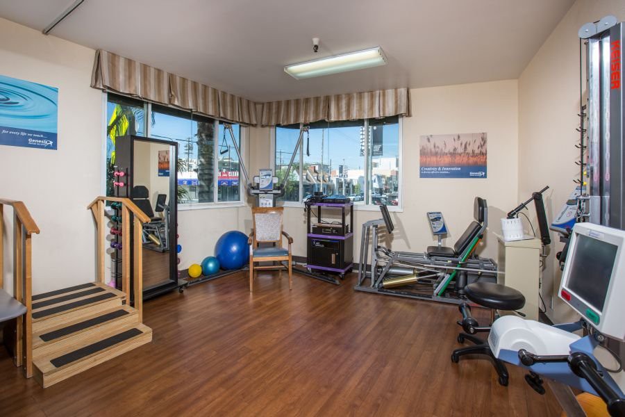 A well-equipped indoor gym with various exercise machines and equipment for fitness and rehabilitation.