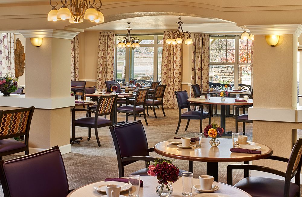 A cozy dining space with elegantly set tables and comfortable seating.