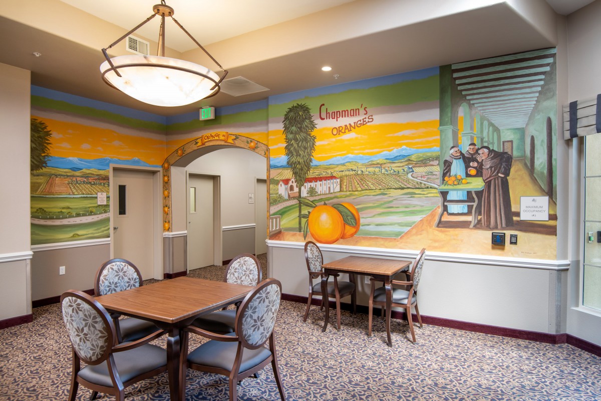 A cozy dining area featuring a vibrant mural depicting a scenic landscape.