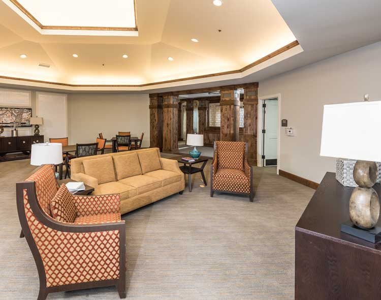 A cozy lobby area featuring comfortable seating with sofas and chairs, accentuated by warm lighting.