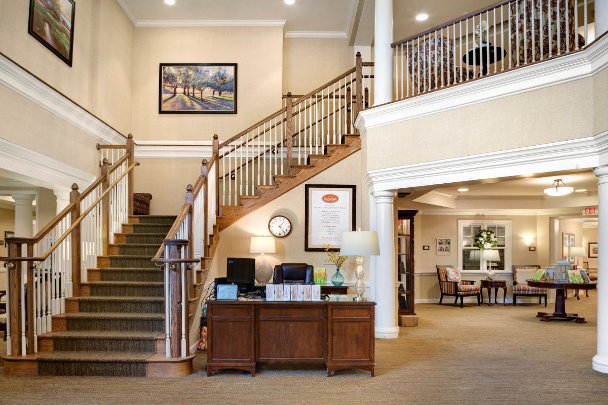 A welcoming lobby area featuring a staircase and a reception desk, leading to an upper floor in an office building.