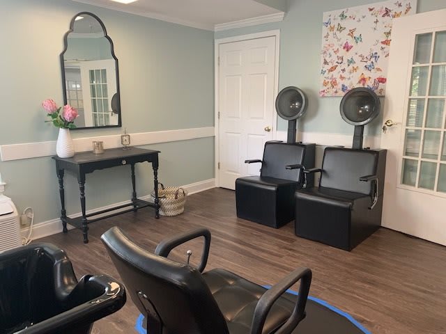 A cozy salon interior featuring hair dryers and comfortable seating.
