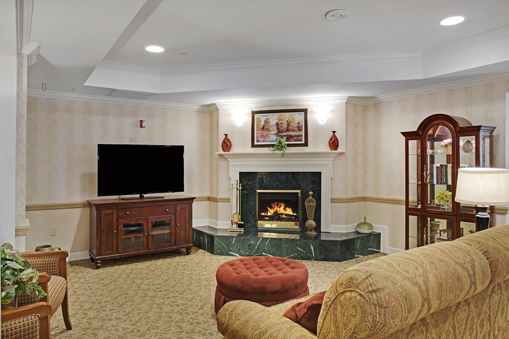 A cozy living room featuring a fireplace, television, and comfortable seating.