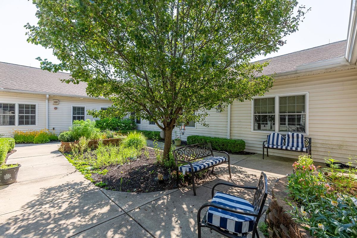 A peaceful courtyard with benches and lush greenery.