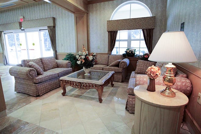 A well-furnished living room featuring a sofa set, coffee table, and decorative indoor plants.