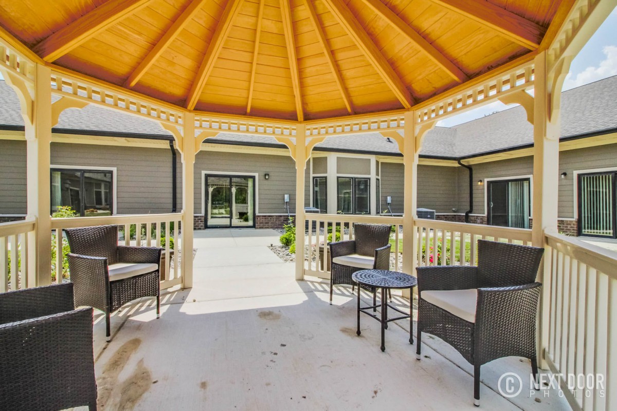 A cozy gazebo with outdoor seating, providing a shaded area in the backyard.