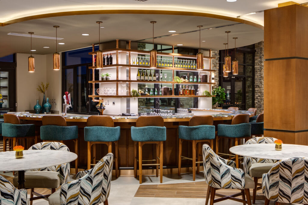 A modern bar with stylish seating and well-organized shelves.