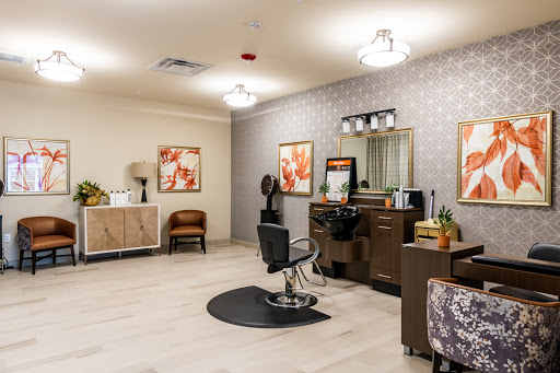 A beautifully designed hair salon featuring modern furniture and elegant lighting.