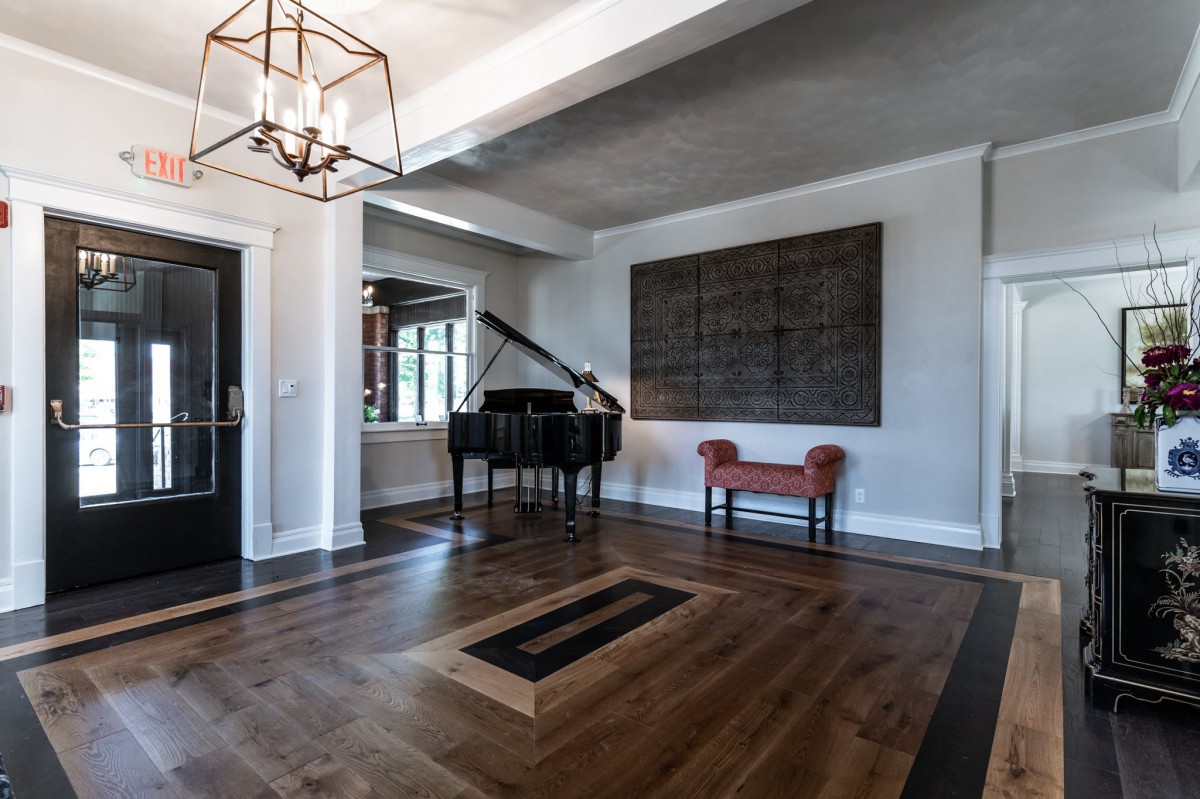 A modern living room featuring a grand piano and stylish decor.