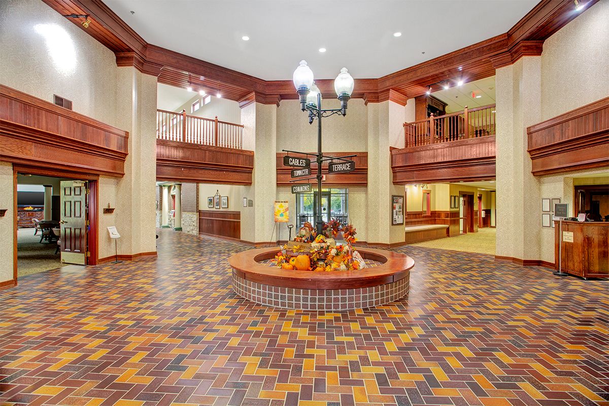A spacious hotel lobby featuring intricate woodwork and patterned flooring.