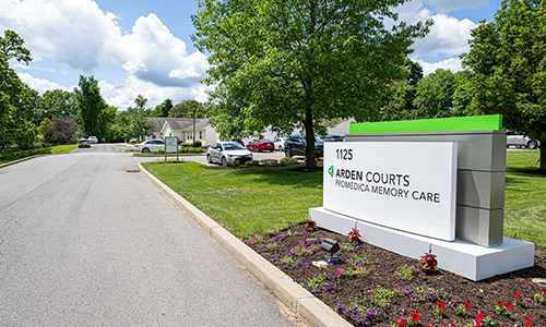 The entrance to Arden Courts featuring a sign and well-maintained landscaping.