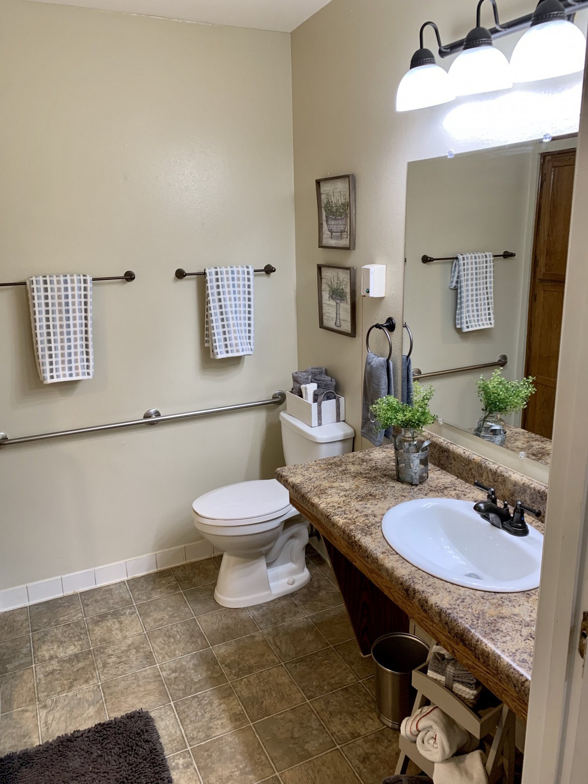 A well-organized bathroom with a sink, toilet, and decorative elements.