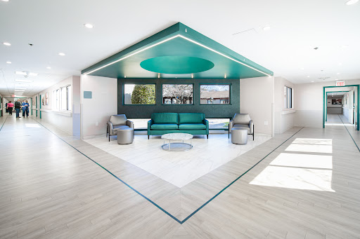 A modern living room featuring a unique architectural design with green accents and minimalist furniture.