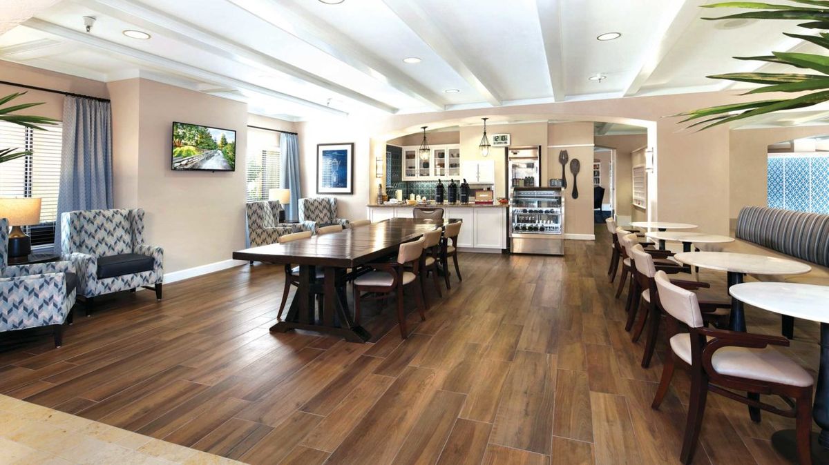 Modern kitchen and dining area with hardwood floors and open layout.