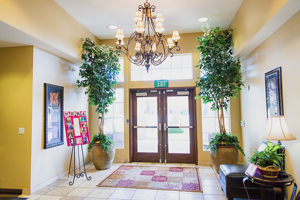 A well-decorated lobby entrance with a chandelier and potted plants.