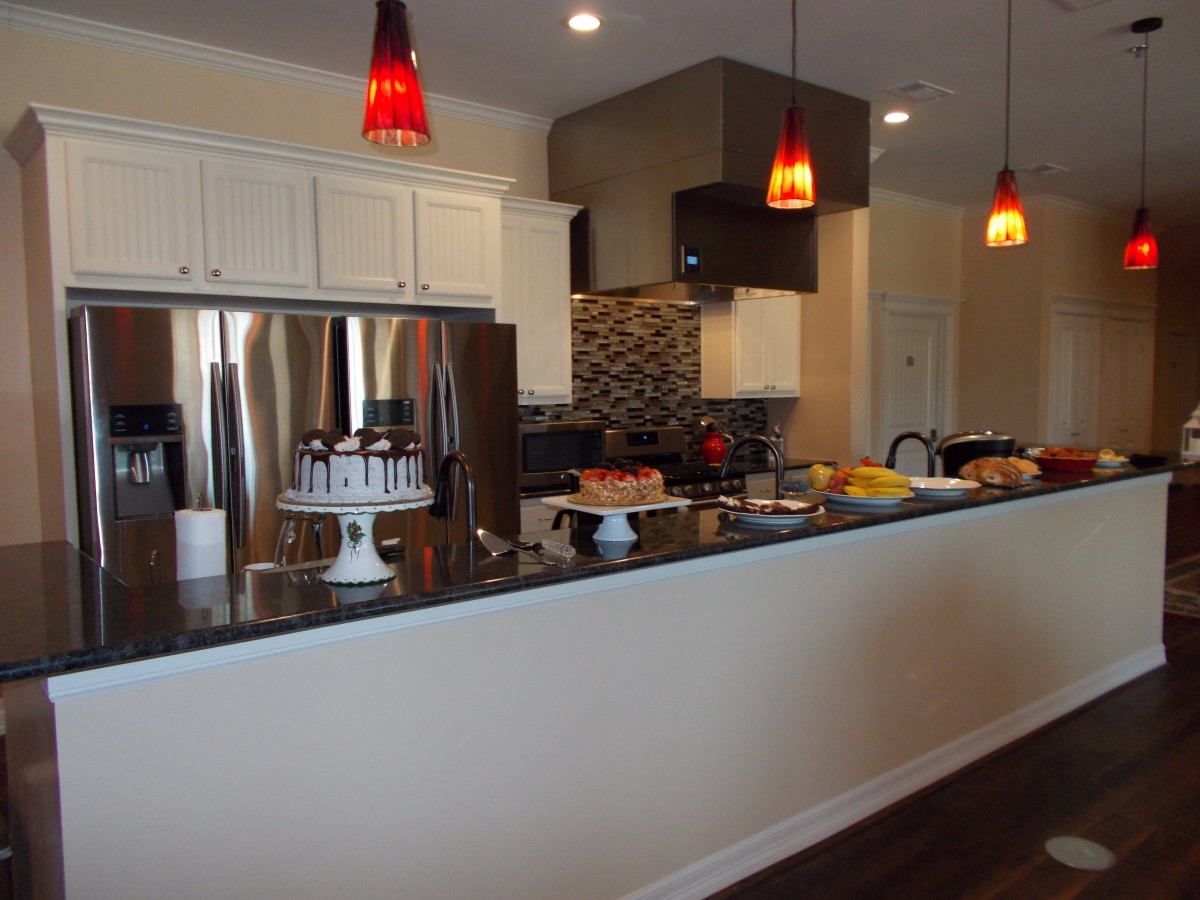 A modern kitchen with stainless steel appliances and stylish pendant lighting.