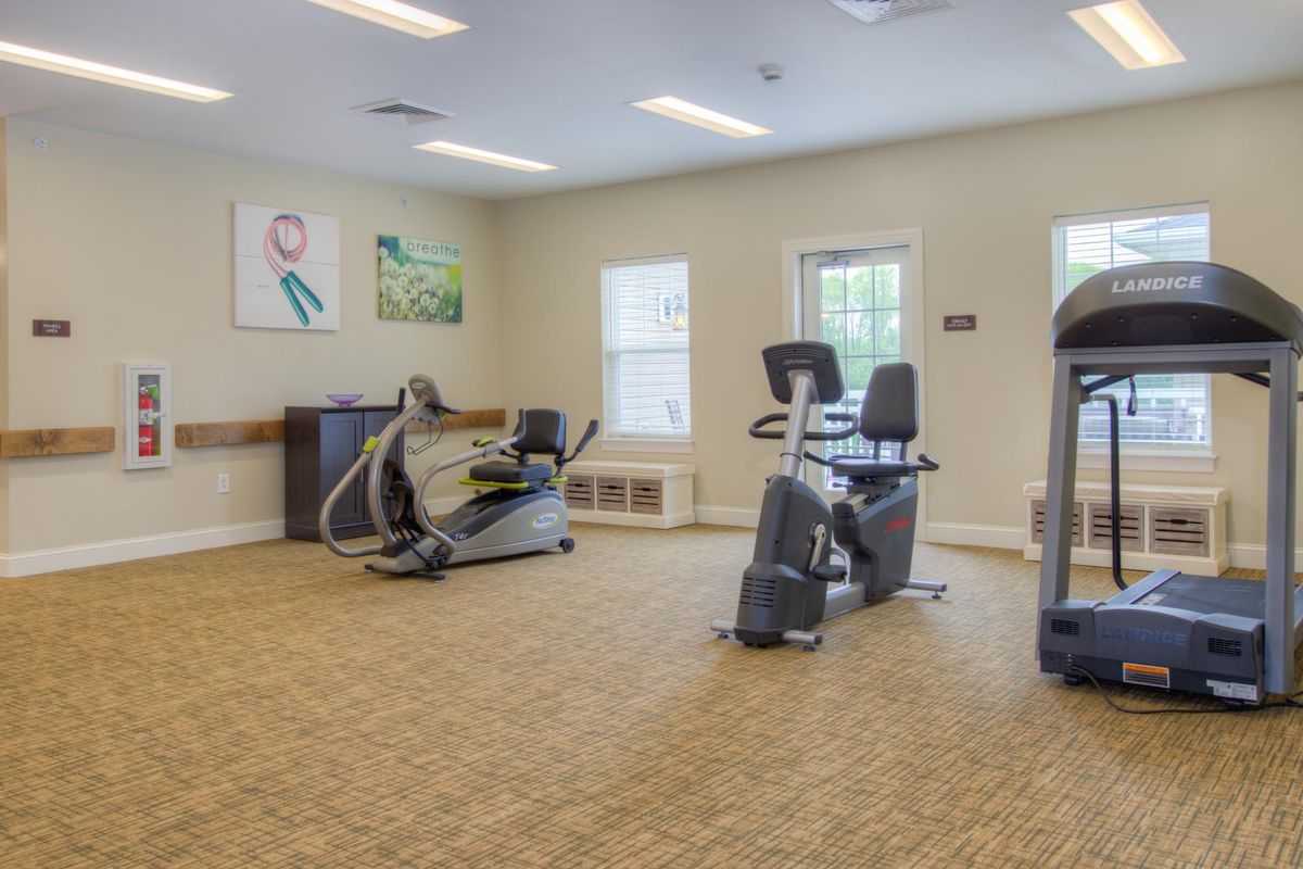 A well-lit gym with various fitness equipment and exercise machines.