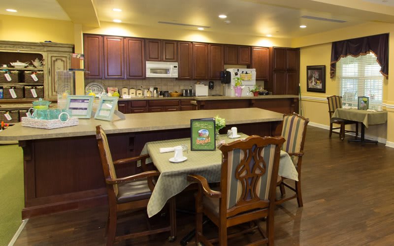 A cozy kitchen with a small dining table and chairs, surrounded by wooden cabinets and modern appliances.