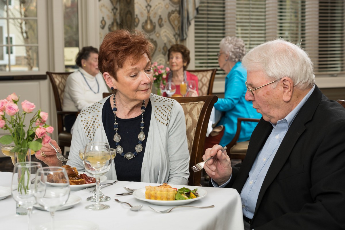An elderly couple enjoying a meal together at a restaurant.