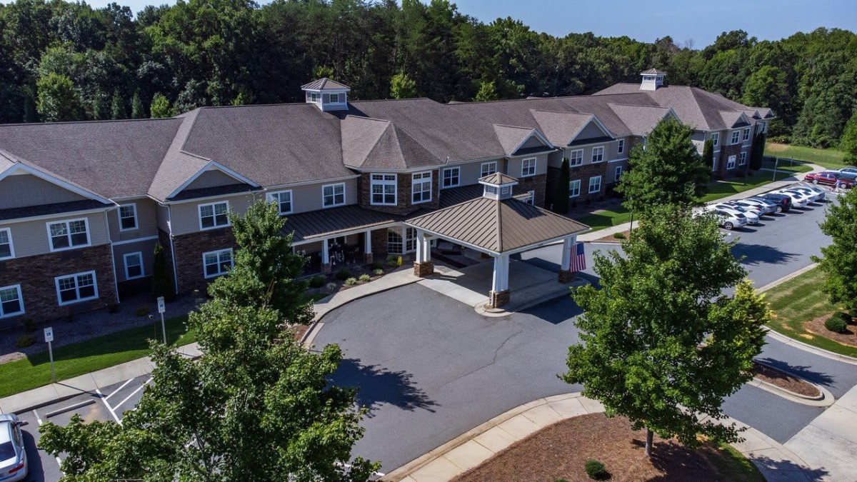 Aerial view of a large residential building surrounded by trees.