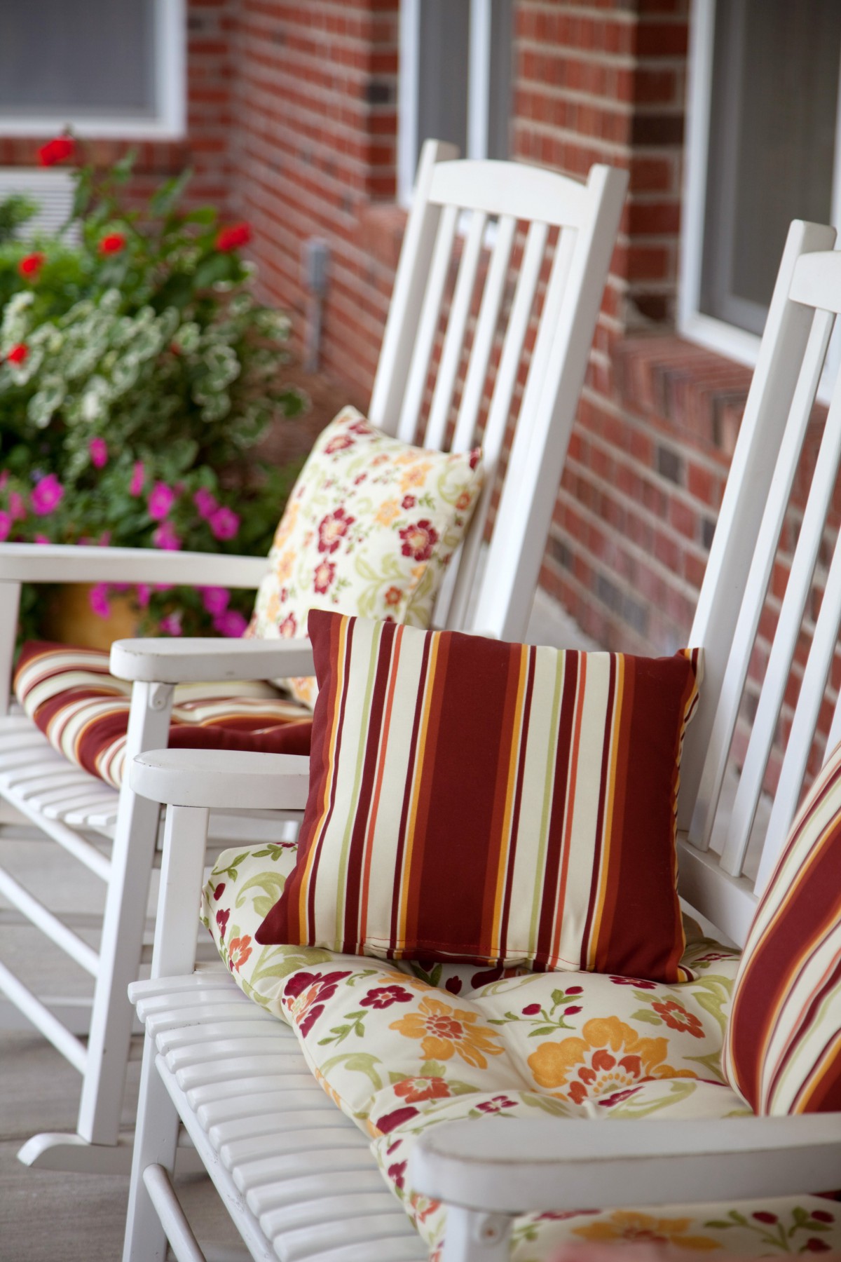 Cozy rocking chairs with patterned cushions on a porch.