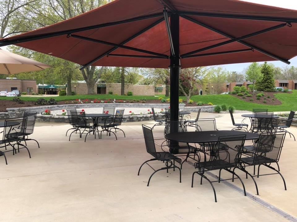 An outdoor patio area with tables, chairs, and large umbrellas.