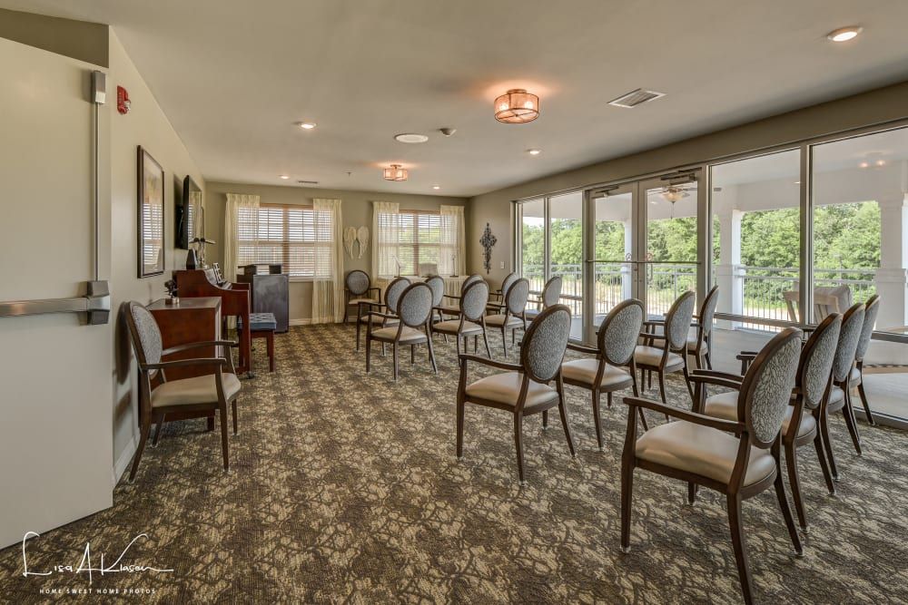 A well-lit conference room with rows of elegant chairs and large windows.