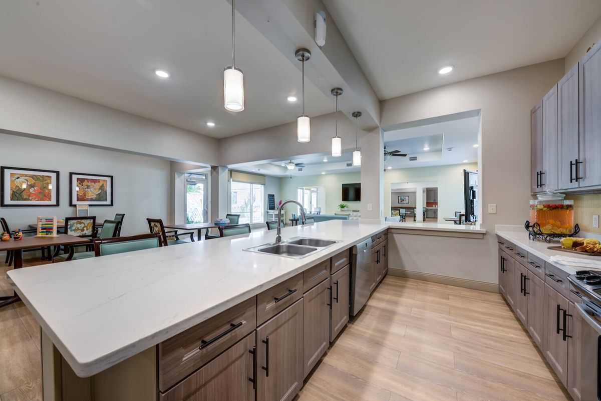 A modern kitchen with sleek countertops, pendant lighting, and spacious cabinetry.