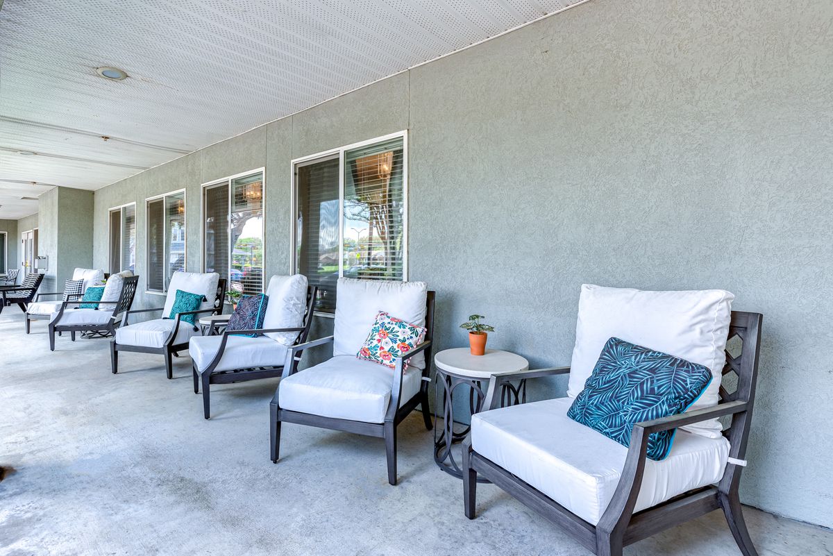 A cozy patio area with comfortable chairs and colorful decor pillows.