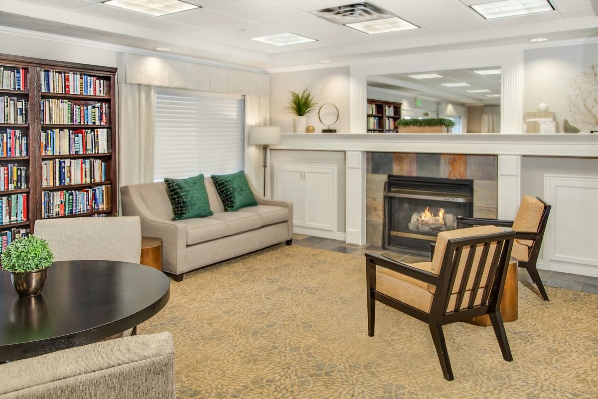 A cozy living room with a modern fireplace, comfortable seating, and stylish decor.