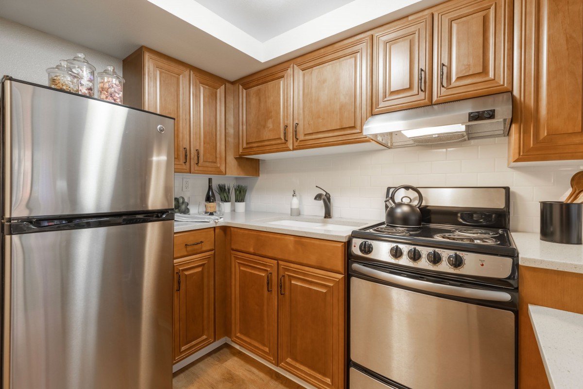 A modern kitchen with wooden cabinets and stainless steel appliances.
