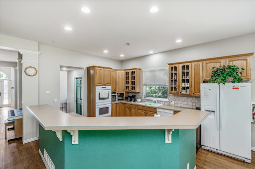 A modern kitchen featuring wooden cabinetry, a spacious countertop, and bright lighting.