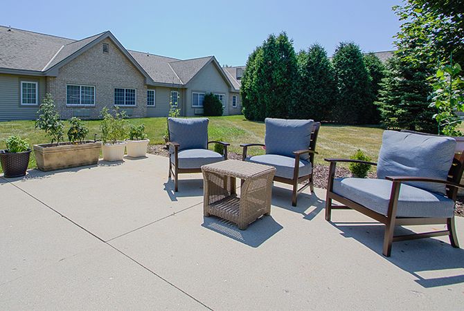 Outdoor patio setup with chairs and a table in a residential backyard.