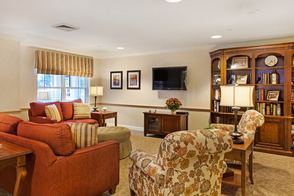A cozy living room with comfortable seating and a mounted TV.