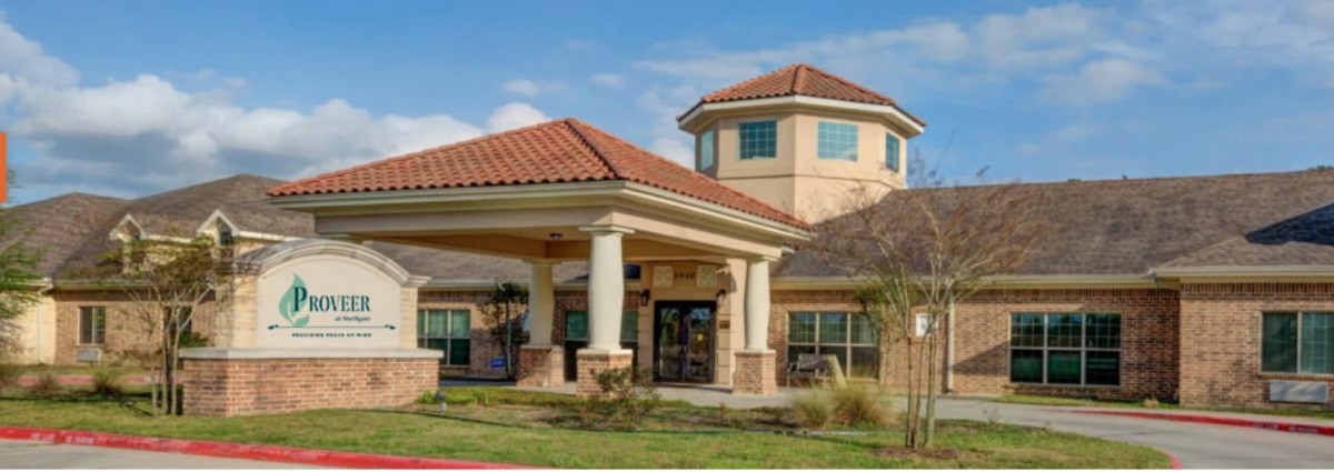 A modern building with a prominent entrance and landscaped surroundings.