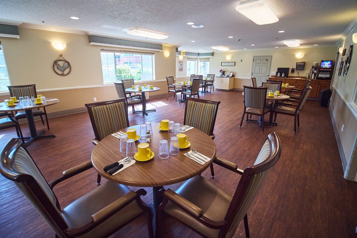 A cozy dining room with neatly arranged tables and chairs, set for a meal.