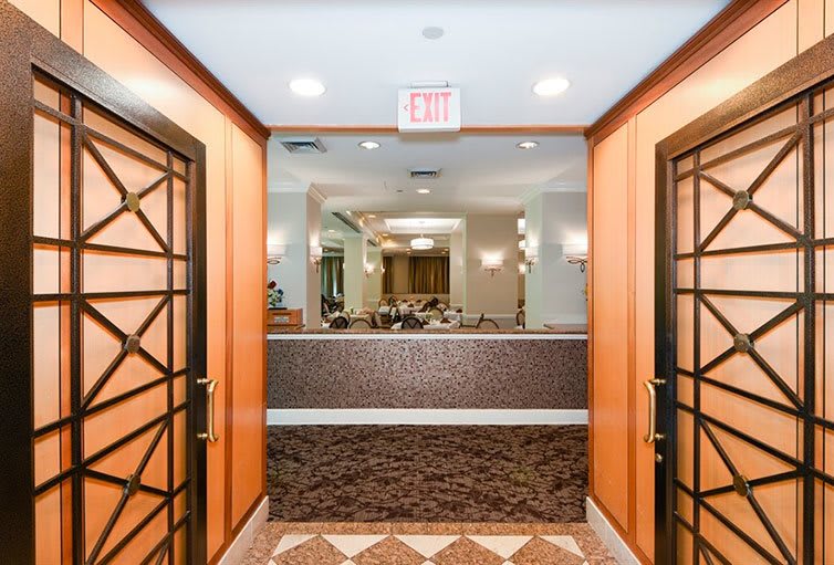 A well-lit hotel lobby entrance with elegant decor and a patterned floor.