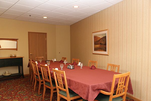 A neatly arranged conference room with a large table and chairs, set for a meeting or meal.