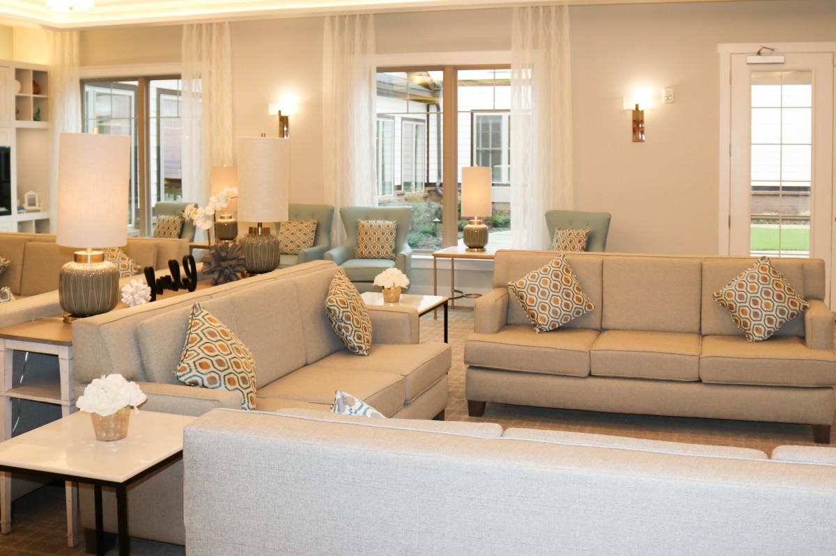 A modern and cozy living room with neutral-toned sofas and elegant lighting.