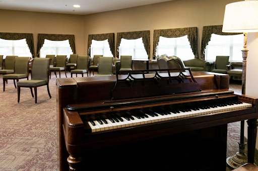 A well-lit interior featuring a piano and comfortable seating, creating a cozy atmosphere for music and gatherings.