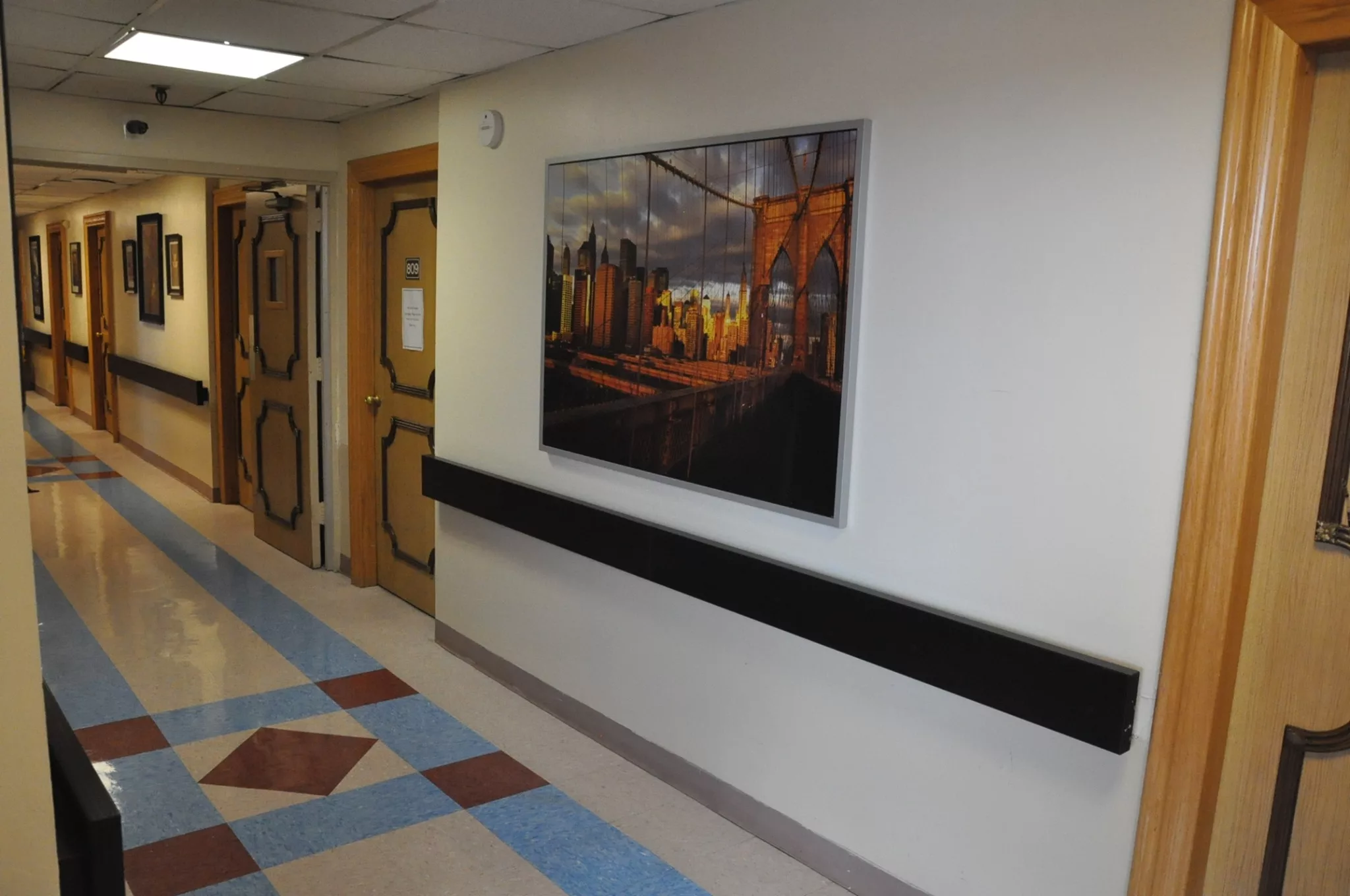 A hospital hallway featuring a colorful painting on the wall.