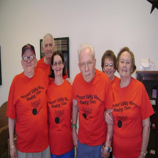 A cheerful group of six people posing together in matching red shirts.