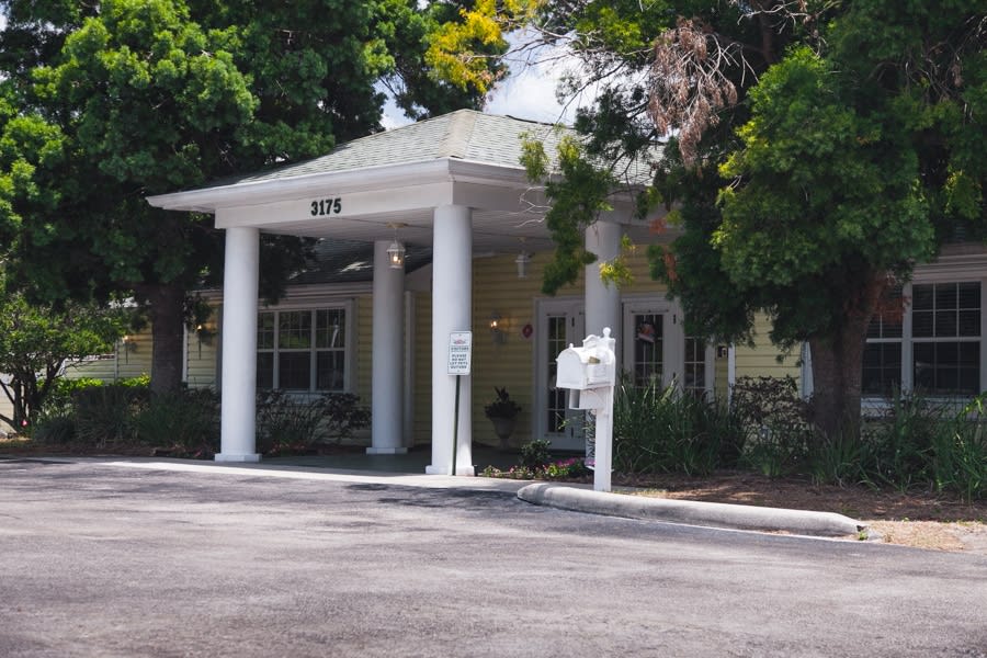 A building entrance with columns surrounded by trees.