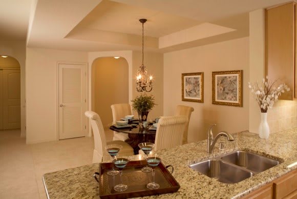 A cozy dining area adjacent to a kitchen with granite countertops and elegant decor.