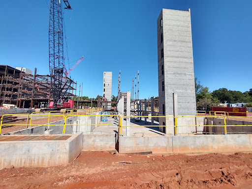 A view of an active construction site featuring concrete structures taking shape under a clear blue sky.