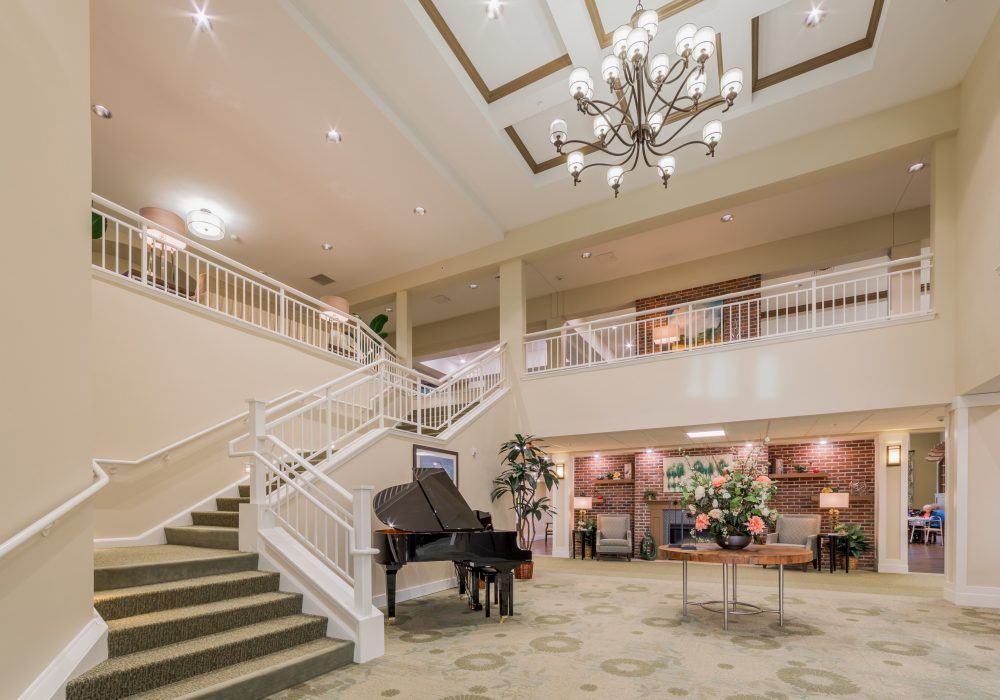 Elegant hotel lobby with a grand staircase and chandelier.