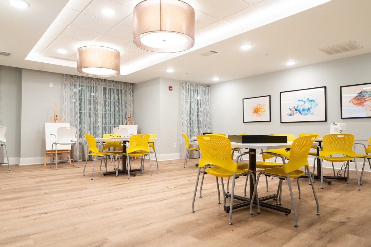 A modern dining area featuring vibrant yellow chairs and contemporary lighting.