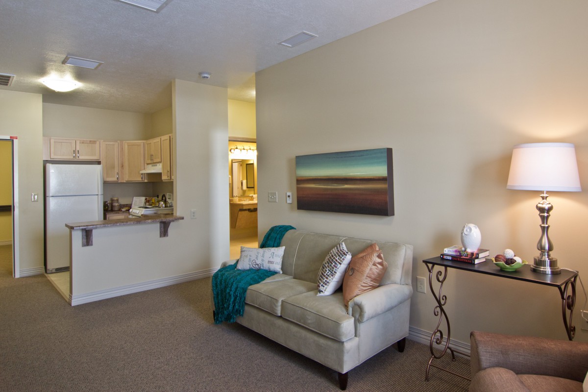 A cozy living room with a sofa, artwork on the wall, and soft lighting.