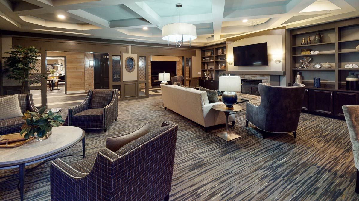 A modern and cozy living room with stylish furniture and a large chandelier.