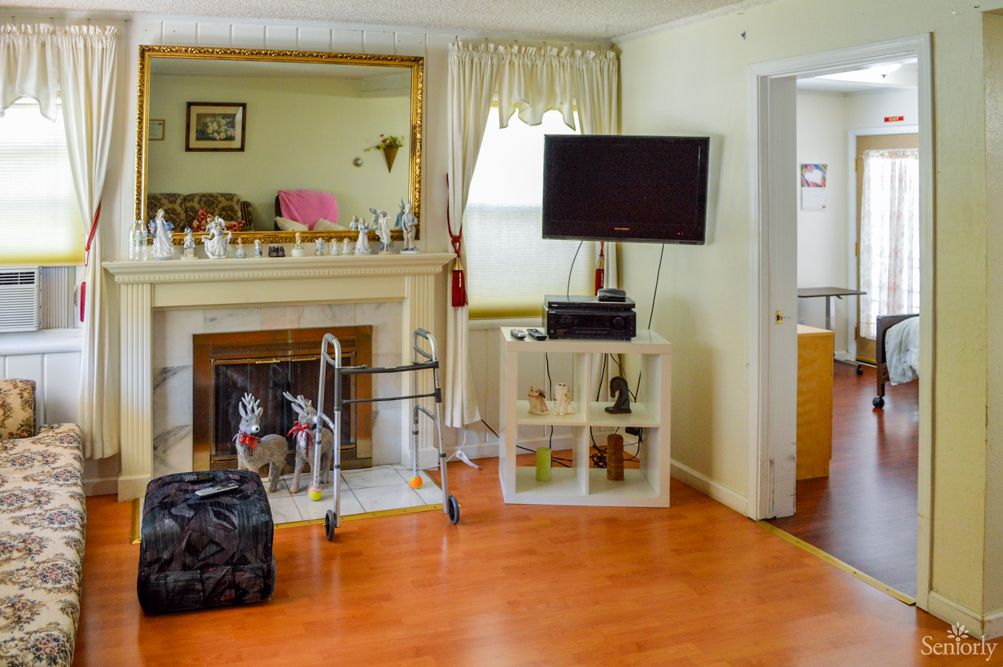 A cozy living room with a fireplace, TV, and various decorations.